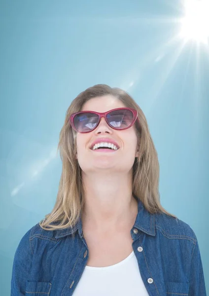Primer plano de la mujer de negocios con gafas de sol y destello sobre fondo azul — Foto de Stock