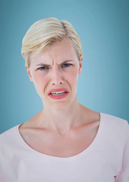 Vrouw met een boos gezicht tegen blauwe achtergrond — Stockfoto