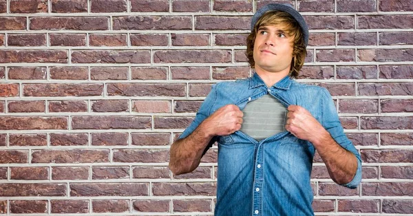 Hipster rasgando camisa contra parede de tijolo — Fotografia de Stock
