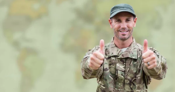 Żołnierz kciuki przeciwko rozmyte mapę z zieloną nakładką — Zdjęcie stockowe