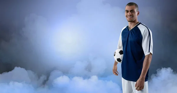 Jogador de futebol sorrindo contra o céu — Fotografia de Stock