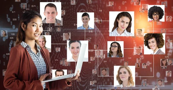 Compuesto Digital Mujer Negocios Sonriente Sosteniendo Portátil Contra Retratos —  Fotos de Stock