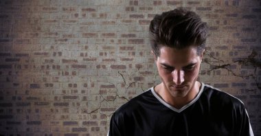 Kahverengi tuğla duvara bakıyordu futbolcu