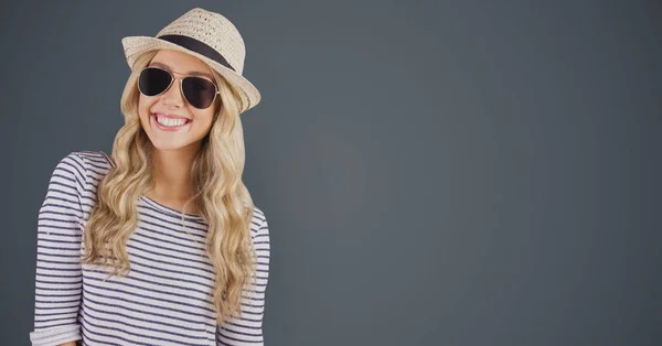 Porträt einer glücklichen Hipsterin mit Sonnenbrille und Sonnenhut vor grauem Hintergrund — Stockfoto