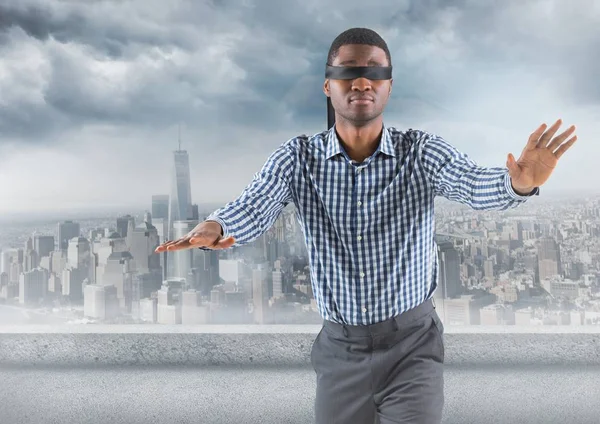 Geschäftsmann mit verbundenen Augen gegen Skyline mit grauen Wolken — Stockfoto