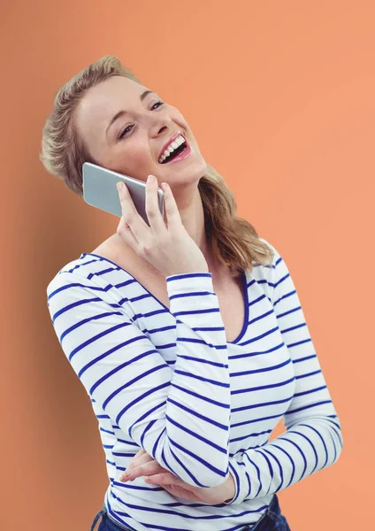 Mujer feliz usando el teléfono inteligente sobre fondo de melocotón —  Fotos de Stock