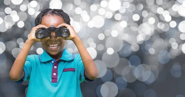 Happy girl holding binoculars over defocused background — Stock Photo, Image