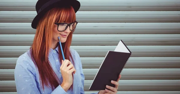 Feminino hipster leitura livro contra a parede — Fotografia de Stock