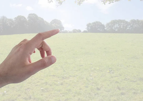 Mano tocando paisaje con campo y cielo — Foto de Stock