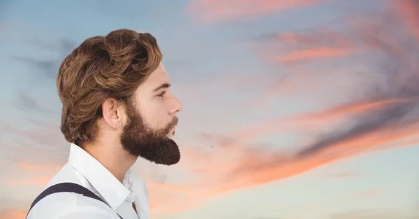 Seitenansicht eines männlichen Hipsters, der gegen bewölkten Himmel wegschaut — Stockfoto