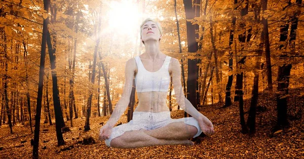 Woman meditating in autumn forest — Stock Photo, Image