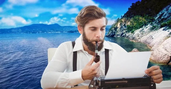 Hipster rookpijp tijdens het gebruik van de schrijfmachine tegen lake — Stockfoto