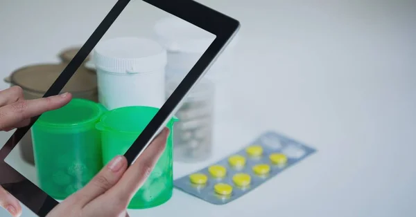 Mãos fotografando medicamentos através de tablet PC — Fotografia de Stock