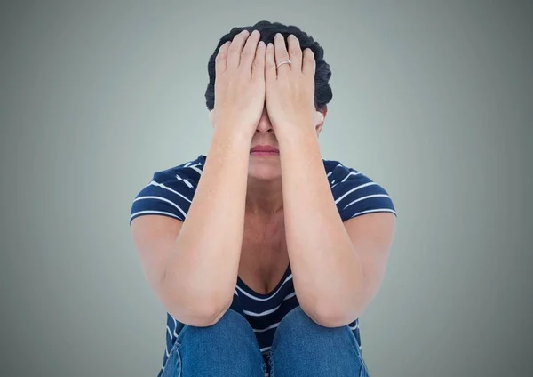 Femme assise avec les mains sur le visage sur fond bleu clair — Photo