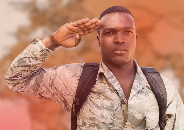 Soldier with backpack saluting — Stock Photo, Image