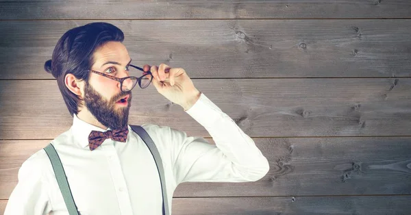 Šokovaný bokovky nošení brýlí proti dřevěné stěny — Stock fotografie