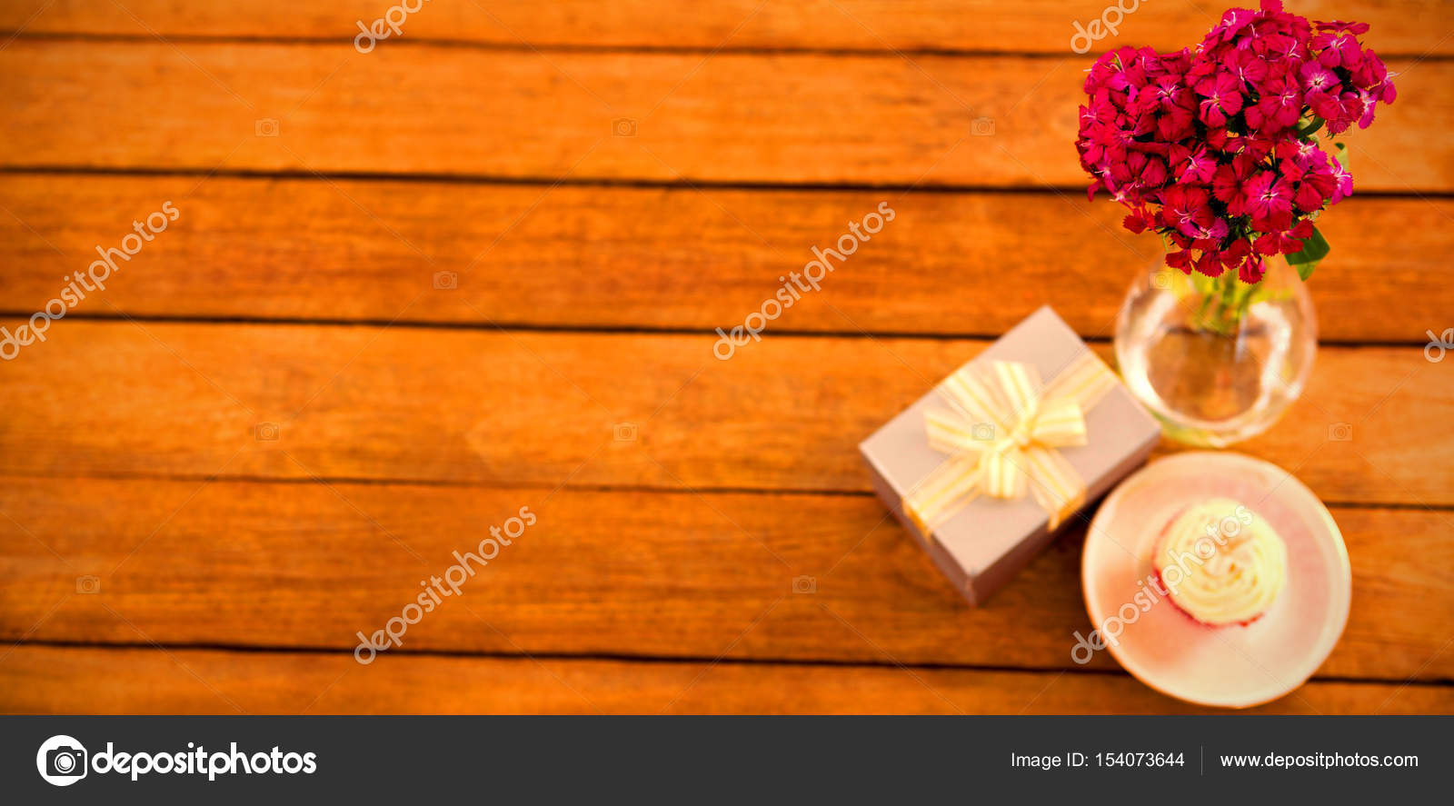 Gift Box And Flower Vase With Cupcake In Plate On Wooden Plank