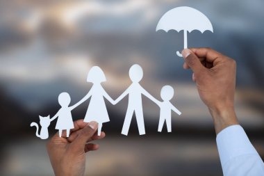 bir şemsiye ve bir aile kağıt tutan el