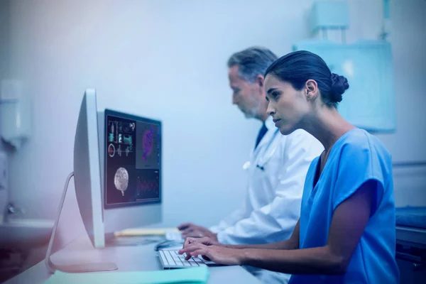 Médico do sexo masculino com enfermeira trabalhando no computador — Fotografia de Stock