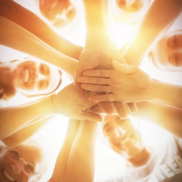 Felices voluntarios poniendo sus manos juntas — Foto de Stock