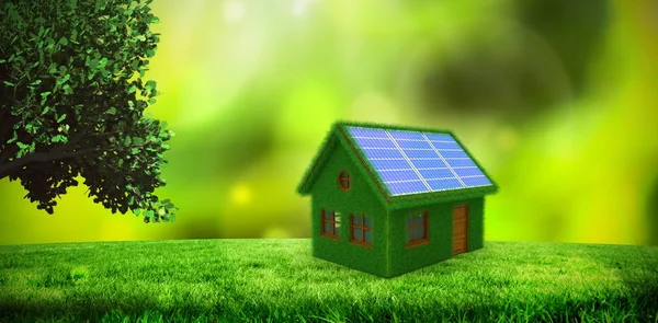 Небольшая модель зеленого дома с солнечными панелями — стоковое фото