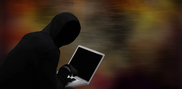 Composite image of hacker using laptop — Stock Photo, Image