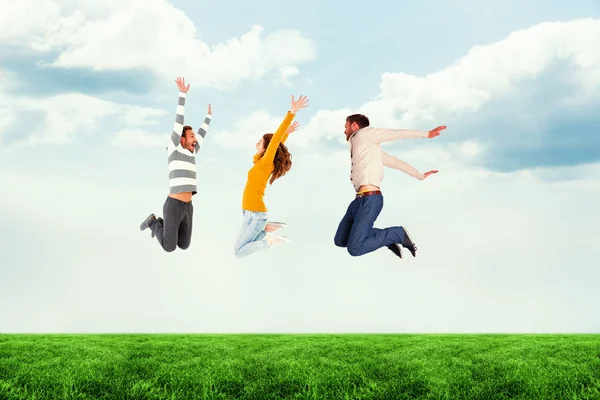 Sammansatt bild av vänner hoppa mot vit bakgrund Royaltyfria Stockfoton