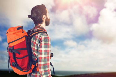 Sırt çantası ile ayakta uzun yürüyüşe çıkan kimse