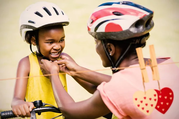 mother clasping her daughters bicycle helmet