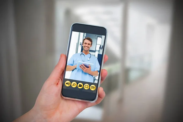 Mão segurando telefone celular com o médico na tela — Fotografia de Stock