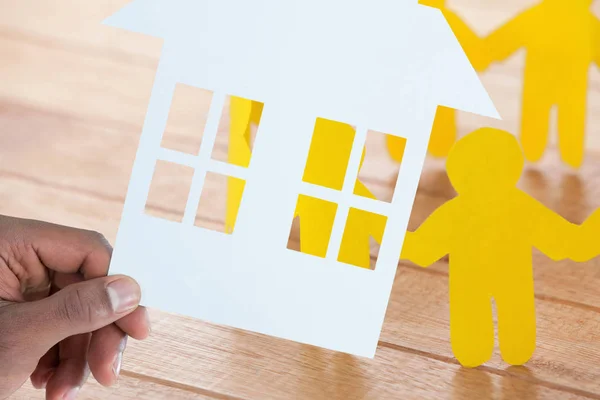 Imagem composta de mão segurando uma casa em papel — Fotografia de Stock