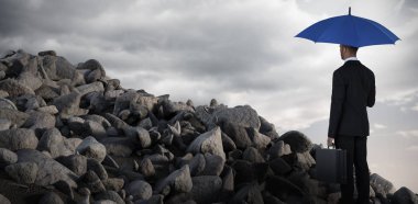 Mavi şemsiye ve Evrak Çantası'nı tutan işadamı