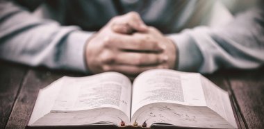 İncil ahşap masa dua ile adam