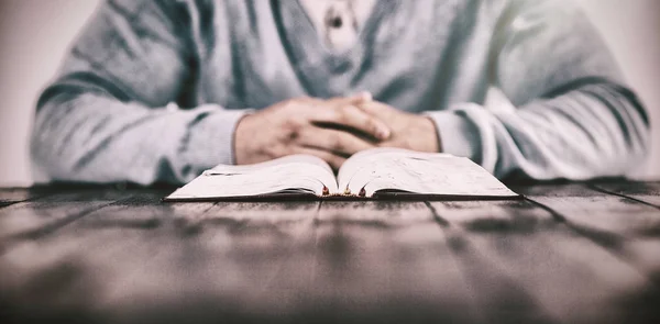 Hombre con la Biblia rezando sobre la mesa — Foto de Stock