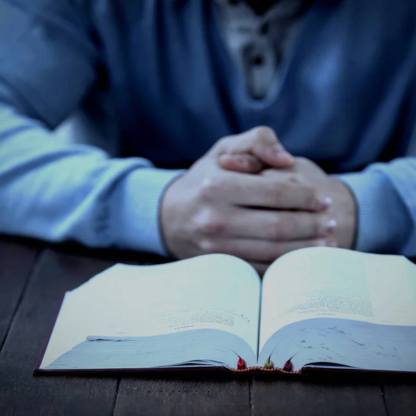 Uomo con la Bibbia che prega a tavola — Foto Stock