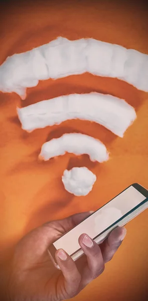 Обрезанная рука с мобильным телефоном по значку wifi — стоковое фото