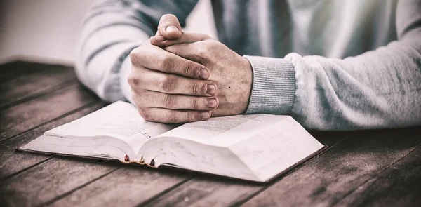 Homem com a bíblia rezando na mesa — Fotografia de Stock