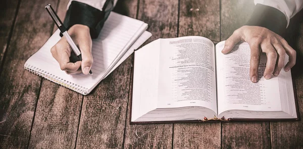 Mujer con Biblia y escritura en bloc de notas —  Fotos de Stock