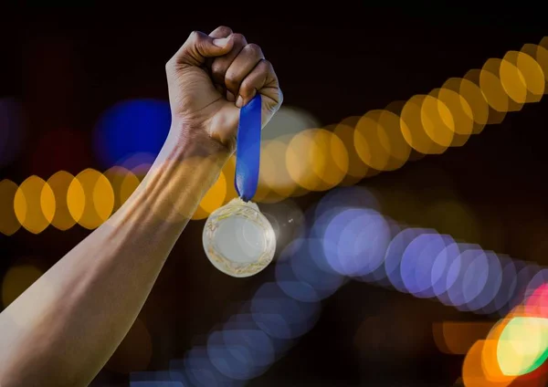 Handen håller medalj vinner med gnistrande ljus bokeh bakgrund — Stockfoto
