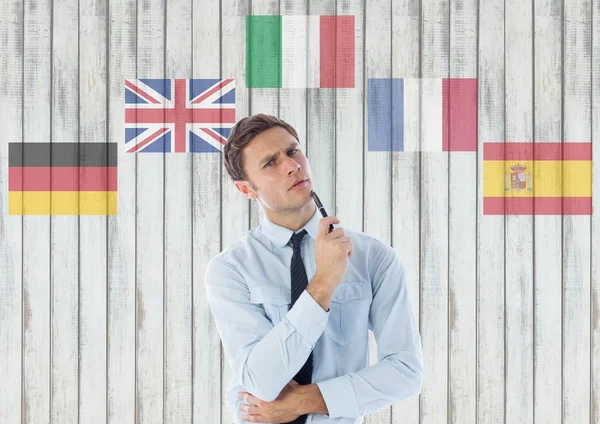 Drapeaux de langue autour de la pensée jeune homme d'affaires — Photo