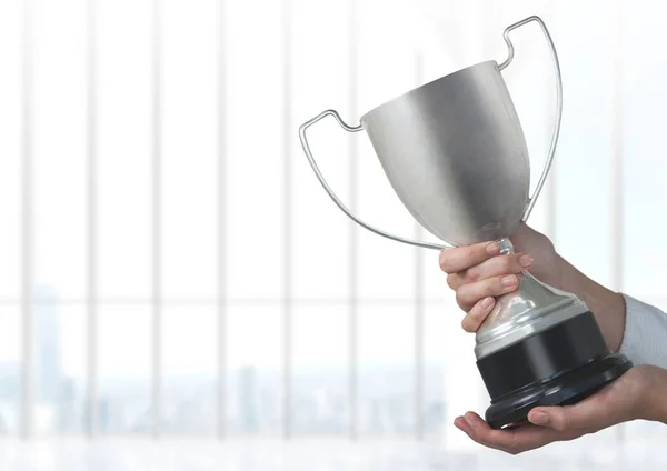 Hand holding trophy against window — Stock Photo, Image