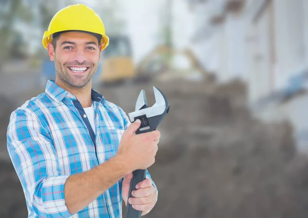 Construction Worker with wrench tool in front of construction site — Stock Photo, Image