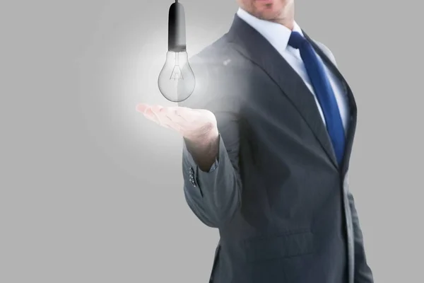 Glödlampa i affärsman händer — Stockfoto