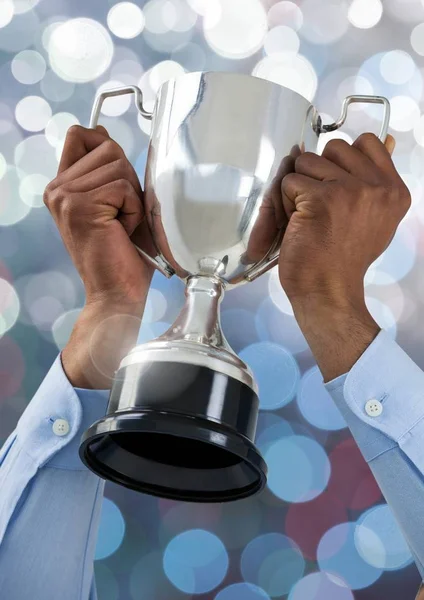 Mãos segurando copo troféu com fundo bokeh luz cintilante — Fotografia de Stock