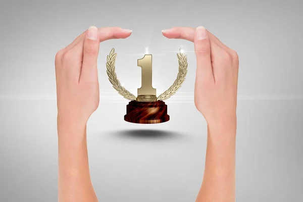 Trophy surrounded by hands against grey background — Stock Photo, Image