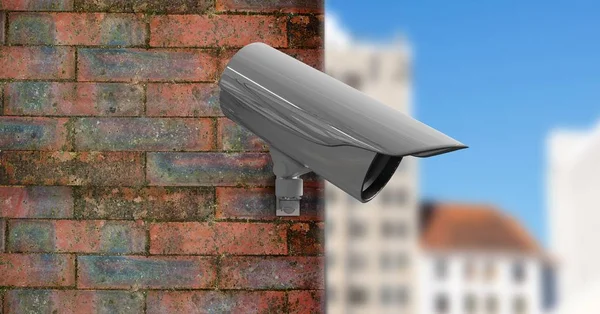 Камера видеонаблюдения на стене с городом на переднем плане — стоковое фото