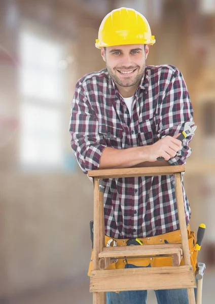 Trabalhador de construção na escada em frente ao canteiro de obras — Fotografia de Stock