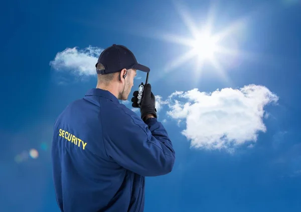 Achteraanzicht van bewaker praten over walkie talkie tegen hemel — Stockfoto