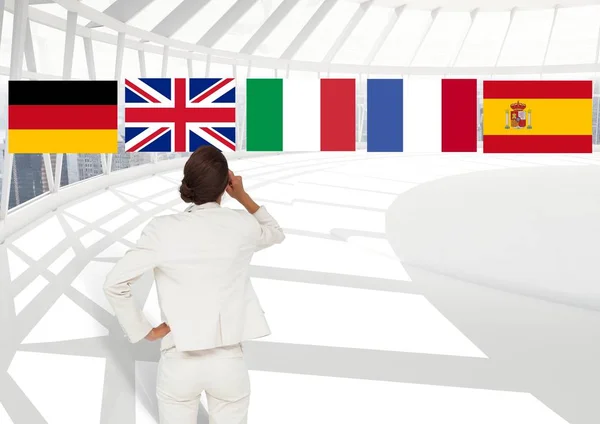 Основные языковые флаги над предпринимательницей в офисе — стоковое фото