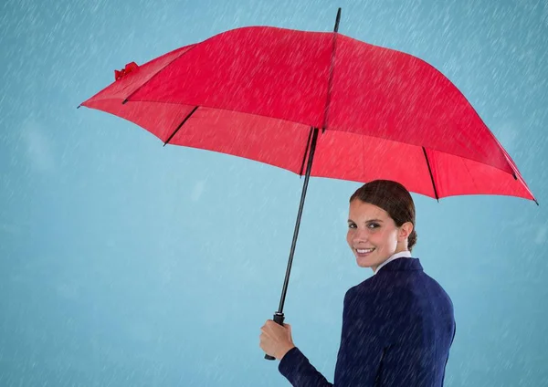 Affärskvinna som tittar över axeln med paraply mot blå bakgrund och regn — Stockfoto